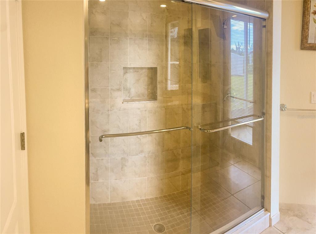 7243 Bahama Swallow Avenue Weeki Wachee, FL 34613 - Photo 14 of 18 a bathroom with a glass shower door