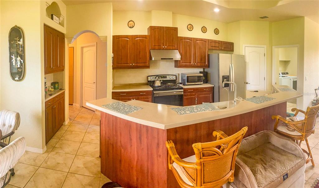 7243 Bahama Swallow Avenue Weeki Wachee, FL 34613 - Photo 2 of 18 a large kitchen with a large counter top stainless steel appliances and cabinets