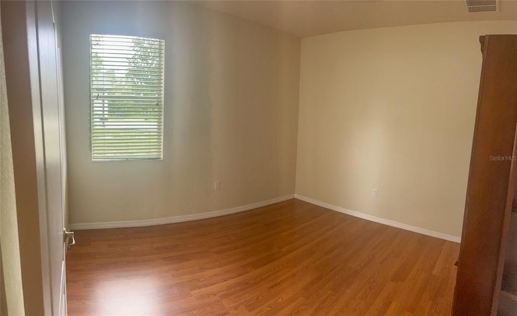 7243 Bahama Swallow Avenue Weeki Wachee, FL 34613 - Photo 6 of 18 a view of an empty room with wooden floor and a window