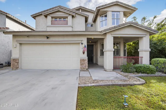 a view of a white house with a small yard and plants
