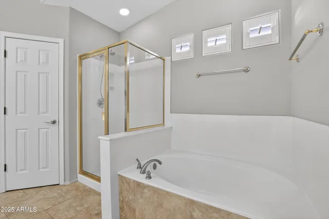a spacious en suite bathroom with a double vanity sink a large mirror and a shower