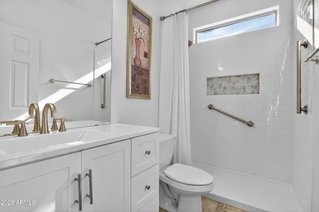 a spacious bedroom with a large bed and a chandelier