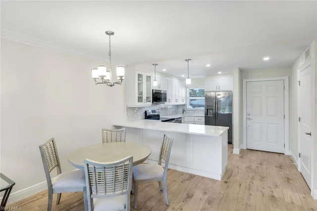 a kitchen with a dining table chairs and wooden floor