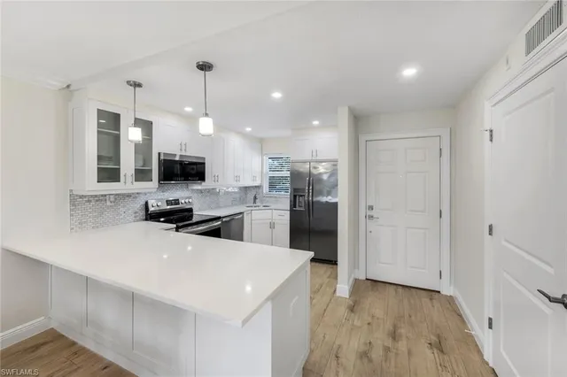 a kitchen with a sink a counter top space stainless steel appliances and cabinets