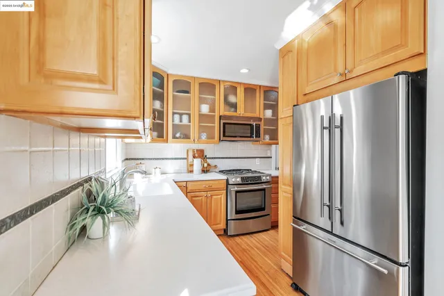 a kitchen with stainless steel appliances granite countertop a refrigerator a stove and a refrigerator