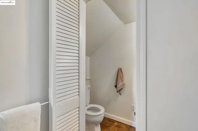a bathroom with a granite countertop toilet and a sink