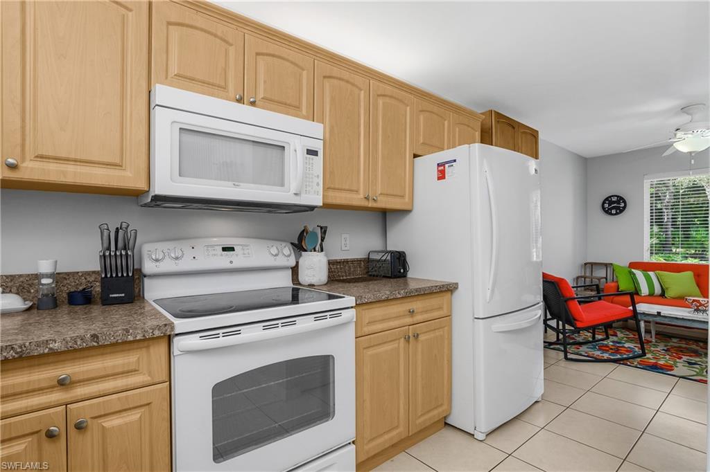 1330 Yesica Ann Circle, Unit I106 Naples, FL 34110 - Photo 11 of 38 a kitchen with stainless steel appliances granite countertop a stove a sink and white cabinets
