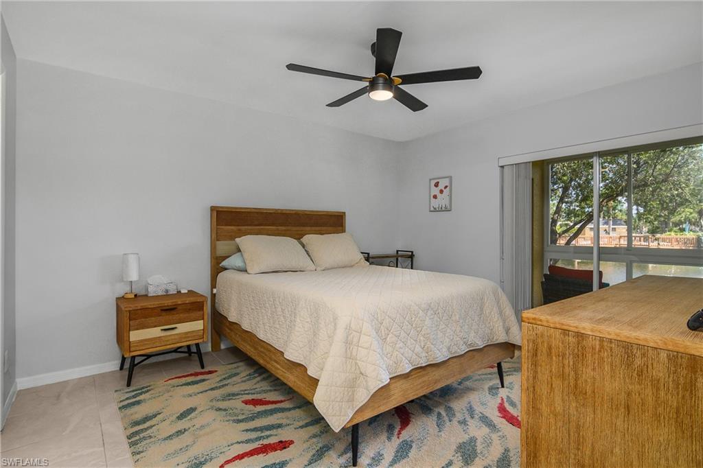 1330 Yesica Ann Circle, Unit I106 Naples, FL 34110 - Photo 16 of 38 a bedroom with a bed and a large window