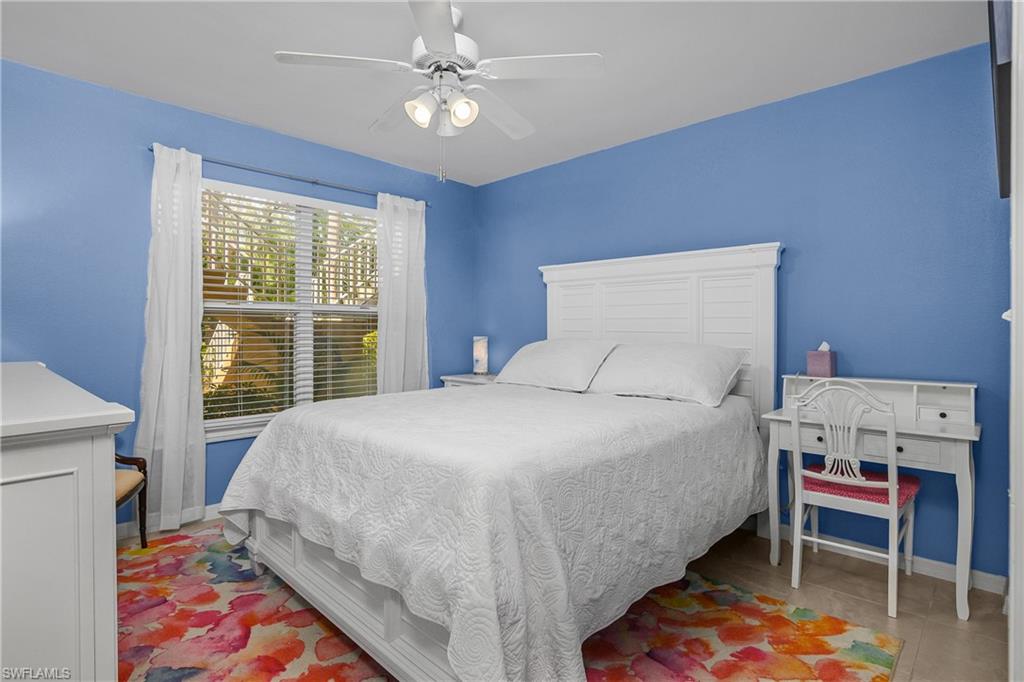 1330 Yesica Ann Circle, Unit I106 Naples, FL 34110 - Photo 20 of 38 a bedroom with a bed and a chandelier