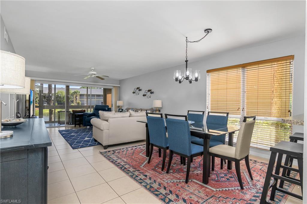 1330 Yesica Ann Circle, Unit I106 Naples, FL 34110 - Photo 4 of 38 a dining room with furniture a chandelier and wooden floor