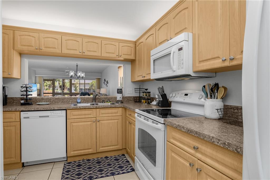 1330 Yesica Ann Circle, Unit I106 Naples, FL 34110 - Photo 9 of 38 a kitchen with stainless steel appliances granite countertop a sink a stove and cabinets