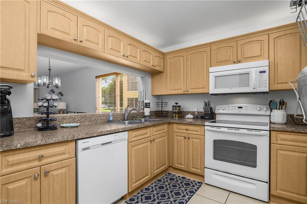 1330 Yesica Ann Circle, Unit I106 Naples, FL 34110 - Photo 10 of 38 a kitchen with granite countertop a sink stove and cabinets