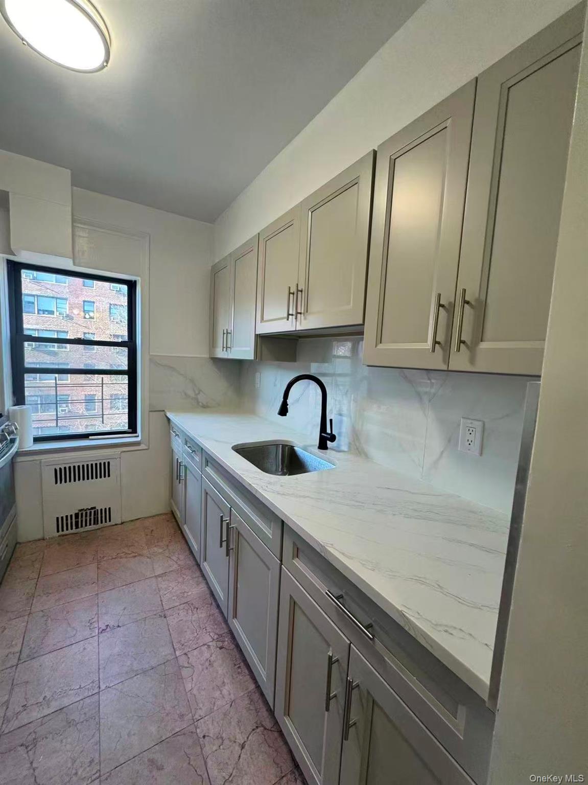99-34 67th Road, Unit 5D Queens, NY 11375 - Photo 2 of 6 a kitchen with a sink a stove and cabinets