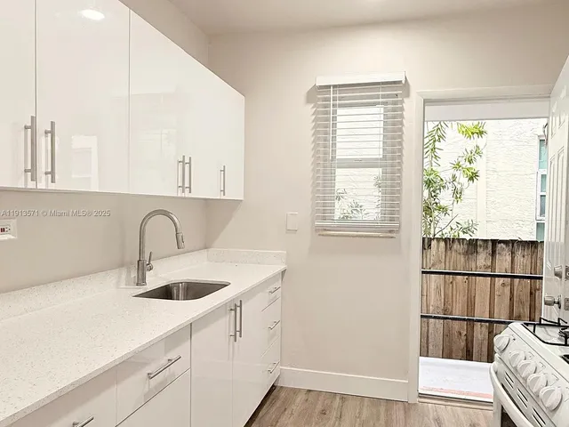 a kitchen with a sink a window and cabinets