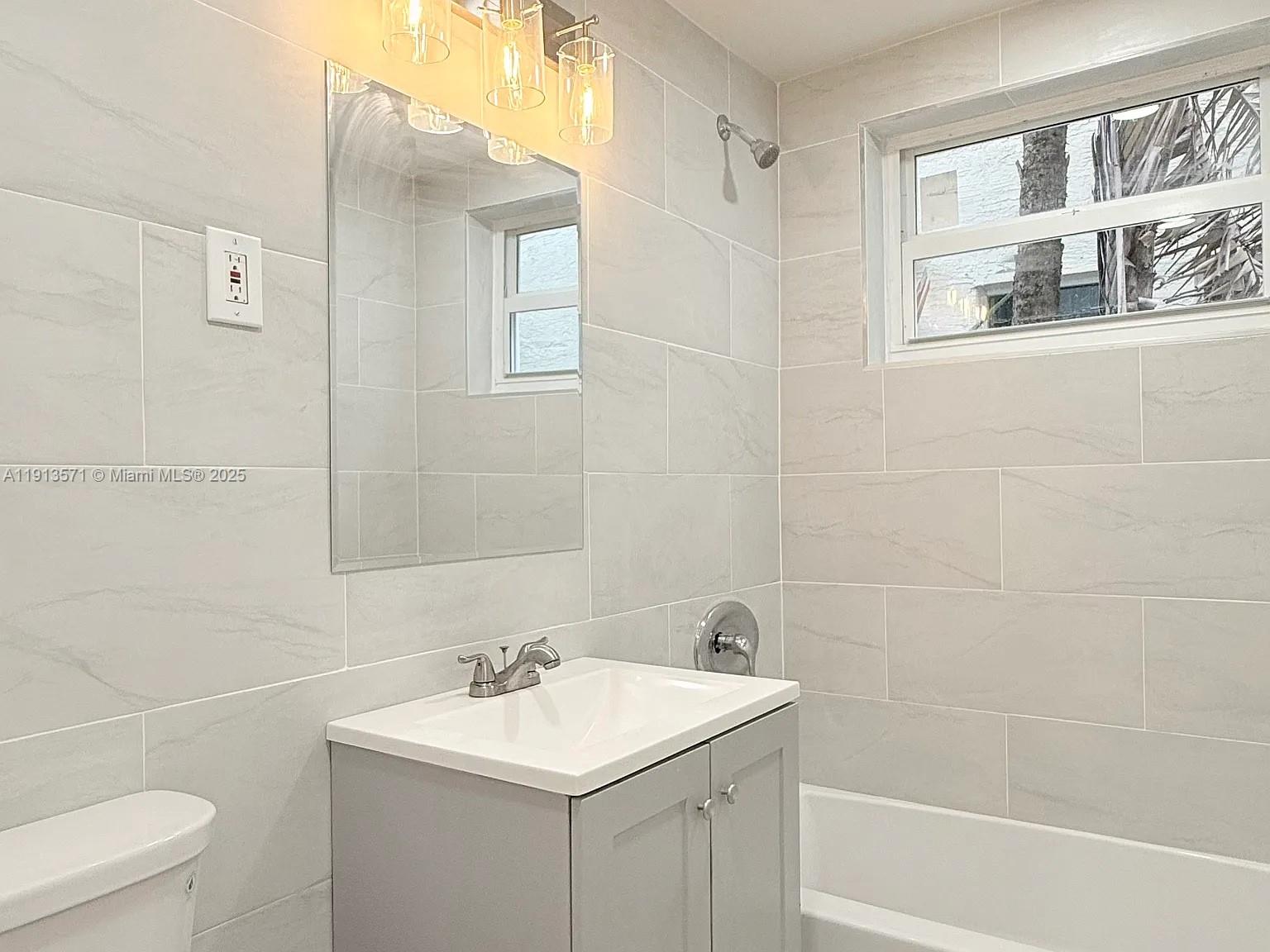 1537 Jefferson Avenue, Unit 3 Miami Beach, FL 33139 - Photo 5 of 10 a bathroom with a sink a toilet and shower
