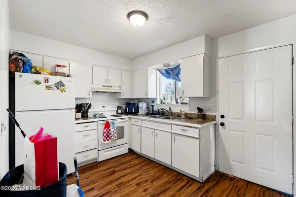 a kitchen with a sink cabinets and wooden floor
