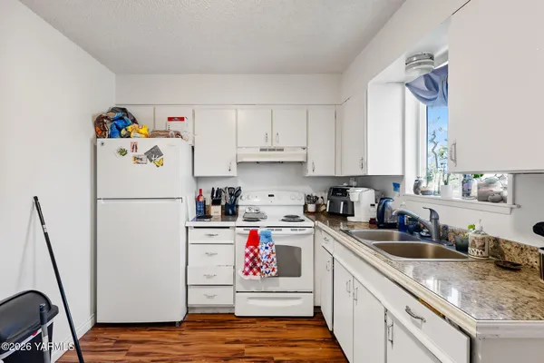 a kitchen with a sink a refrigerator and cabinets