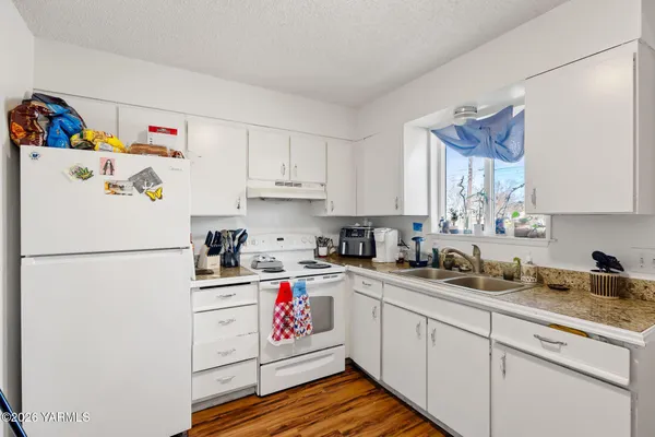 a kitchen with a refrigerator a stove a sink and cabinets