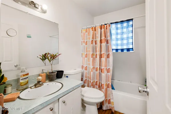 a bathroom with a granite countertop sink mirror vanity and toilet