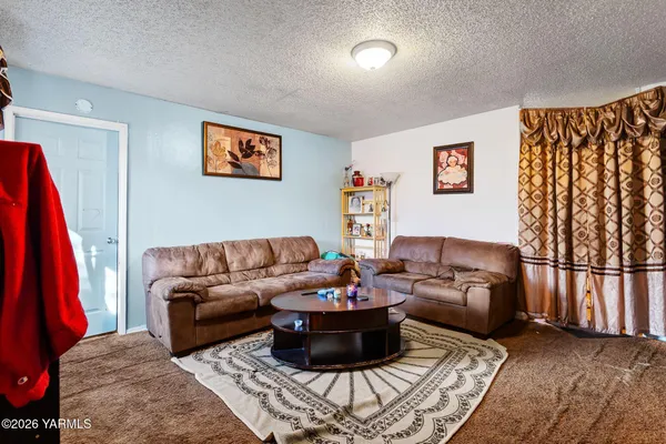 a living room with furniture a couch and a large window