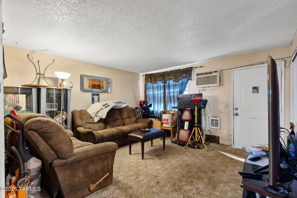 a living room with furniture a window and gym equipment