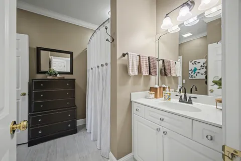 a bathroom with a tub sink vanity and mirror