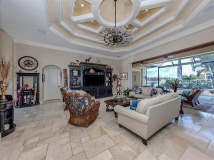 a living room with furniture kitchen view and a chandelier