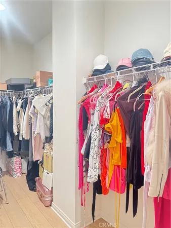 a view of walk in closet with clothes and shoes
