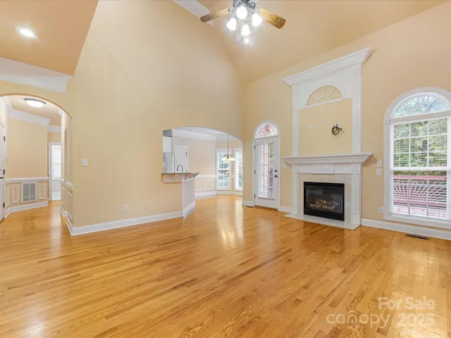 a view of empty room with wooden floor and fireplace