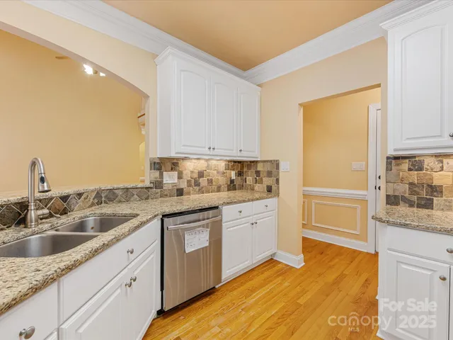 a kitchen with granite countertop a sink and cabinets