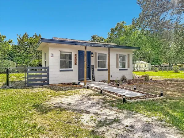 a view of a house with backyard and sitting area