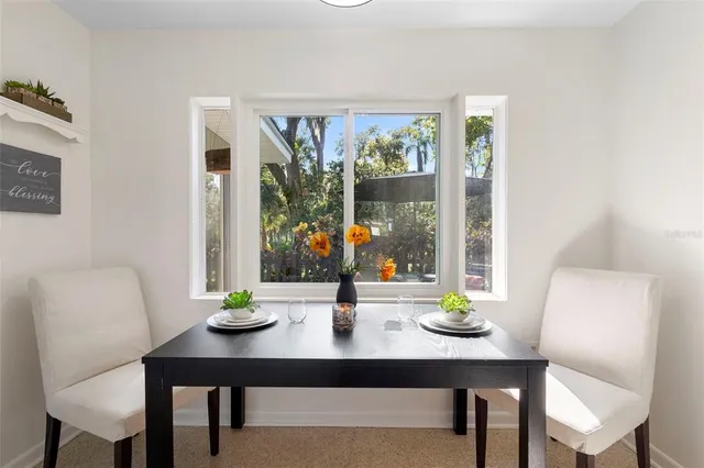 a bedroom with a bed painting on the wall and a potted plant