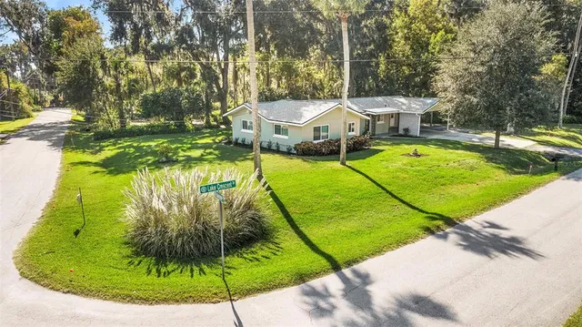 a view of a house with a yard and large tree