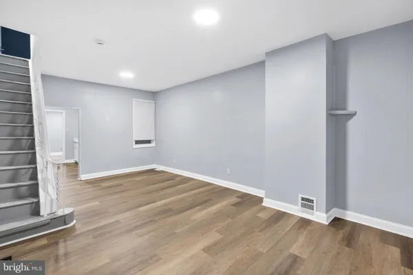 a view of an empty room with wooden floor