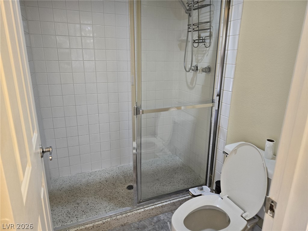 8417 San Ramon Drive Las Vegas, NV 89147 - Photo 19 of 33 Tiled shower with glass doors offers a practical, easy-to-maintain bathing space.