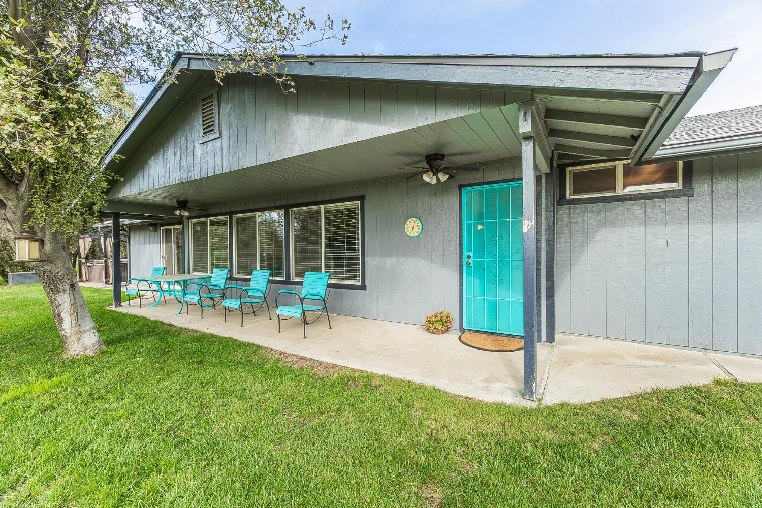 a view of a chair and table in backyard of the house