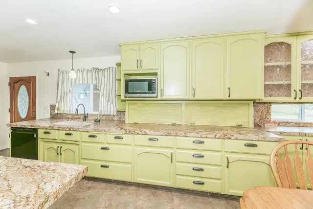 a dining area with a table chairs and a kitchen view