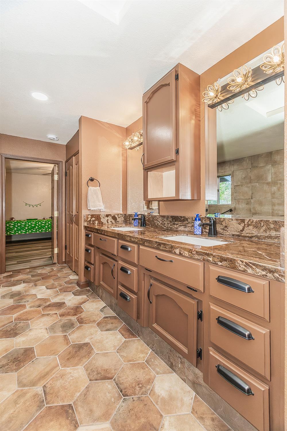 45991 Black Oak Road Coarsegold, CA 93614 - Photo 20 of 67 a spacious bathroom with a double vanity sink and a mirror