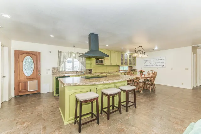 a kitchen with stove and chairs