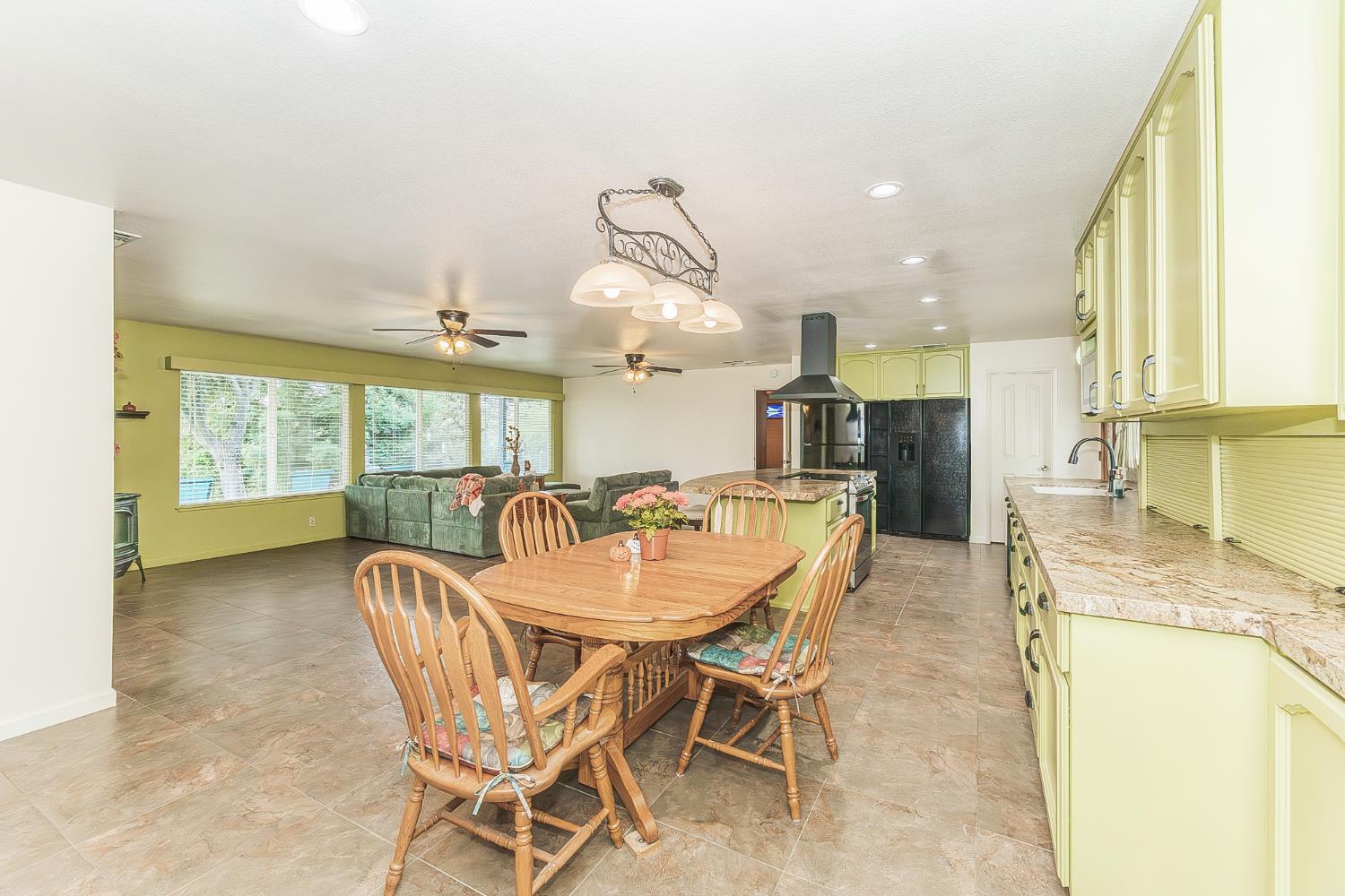 45991 Black Oak Road Coarsegold, CA 93614 - Photo 10 of 49 a dining area with a table chairs and a kitchen view