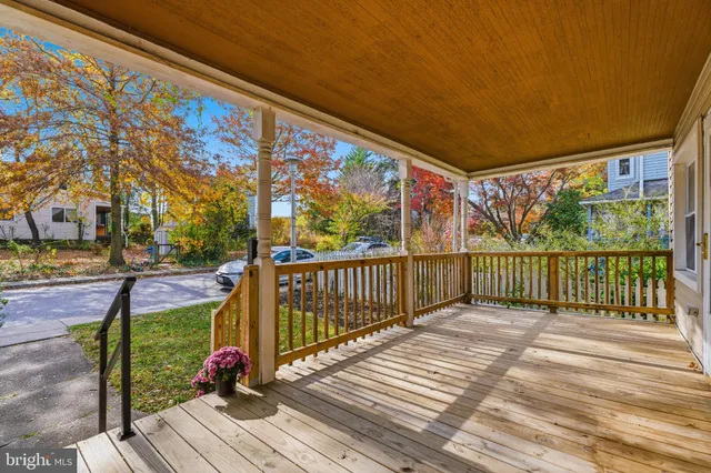 a view of a balcony with wooden floor and iron fence