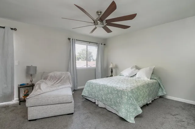 a bedroom with a bed and ceiling fan