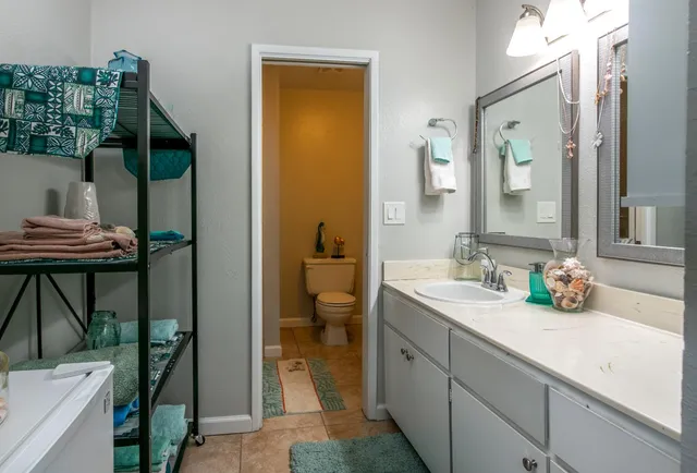 a en suite bathroom with a granite countertop sink and a mirror