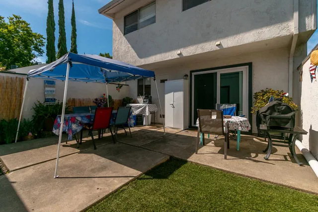 a view of a patio with table and chairs under an umbrella