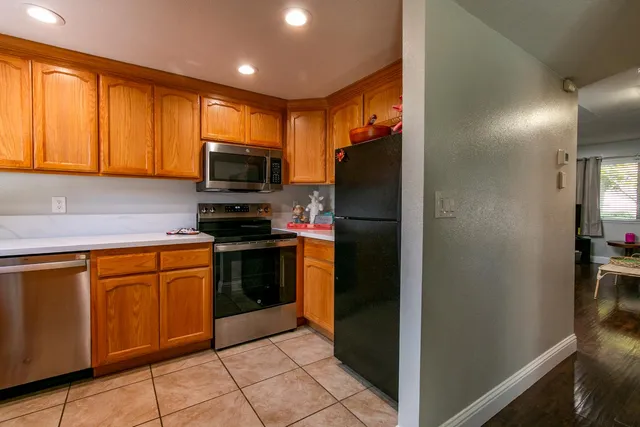 a kitchen with stainless steel appliances granite countertop a refrigerator and a stove top oven