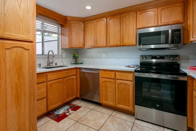 a kitchen with stainless steel appliances granite countertop a stove microwave and sink