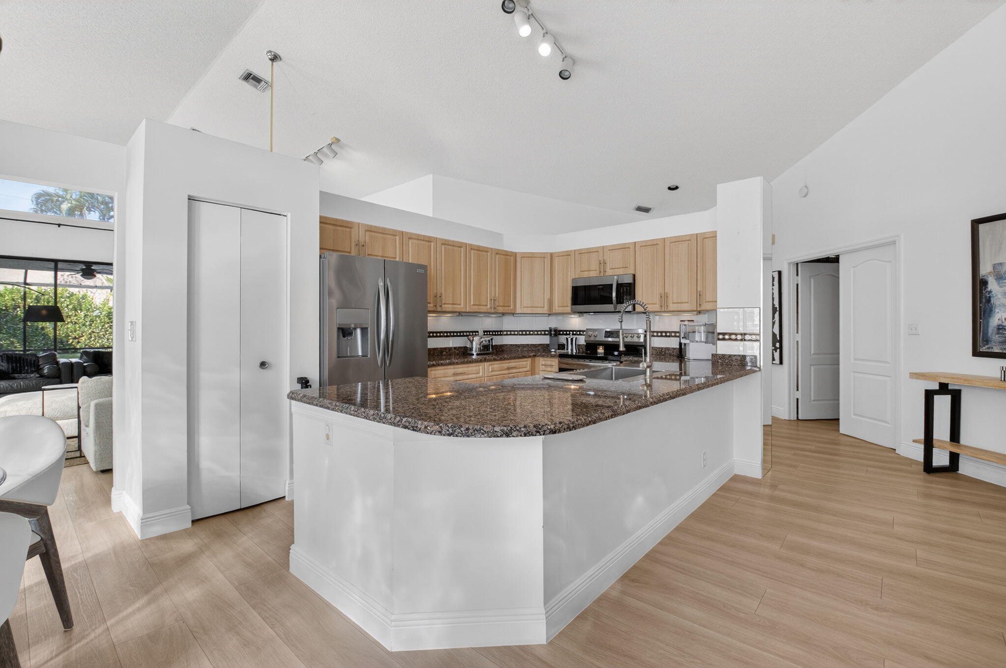 9060 Villa Portofino Circle Boca Raton, FL 33496 - Photo 19 of 47 a large kitchen with stainless steel appliances granite countertop a stove a sink a refrigerator and white cabinets with wooden floor