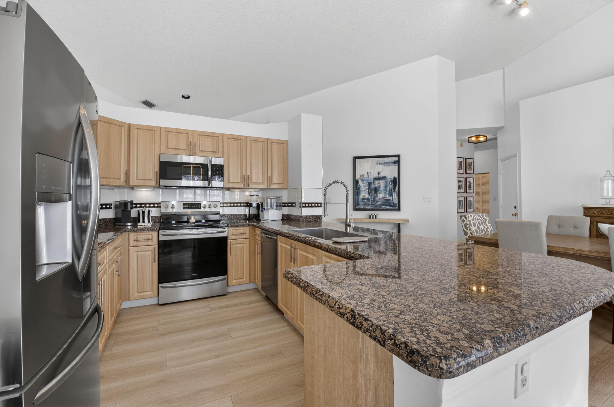 9060 Villa Portofino Circle Boca Raton, FL 33496 - Photo 20 of 47 a kitchen with stainless steel appliances granite countertop a sink dishwasher stove and refrigerator