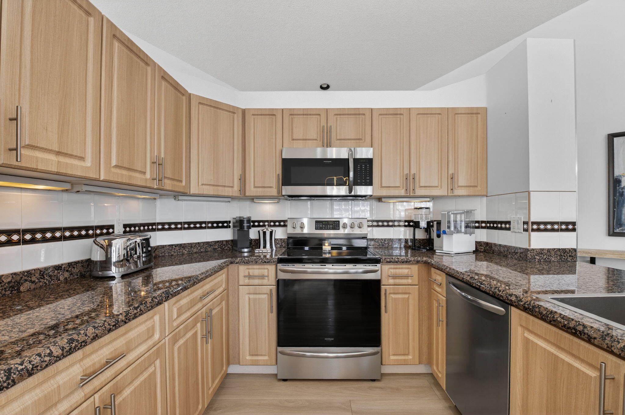 9060 Villa Portofino Circle Boca Raton, FL 33496 - Photo 22 of 47 a kitchen with stainless steel appliances granite countertop a stove a sink and a microwave