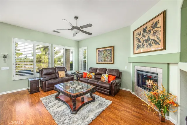 a living room with furniture a fireplace and a large window